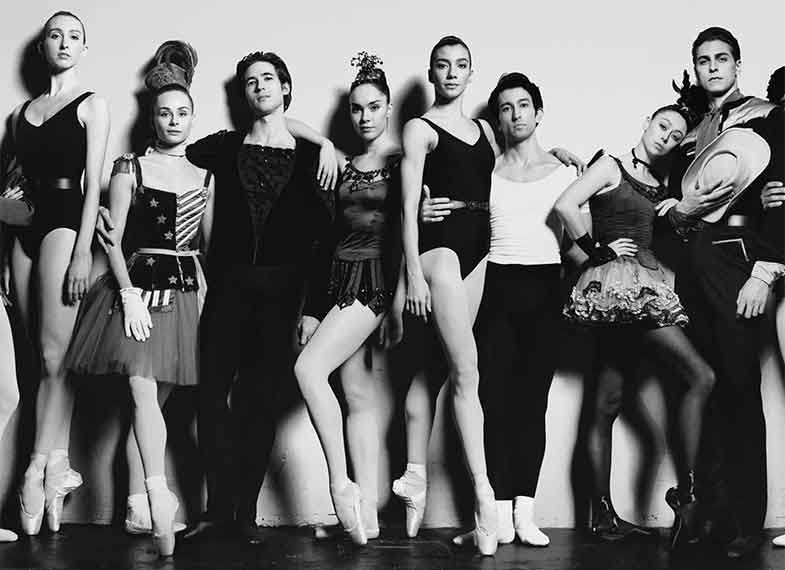 A group of dancers stand next to each other in a line