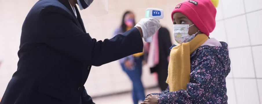 school staff checking the temperature of a student