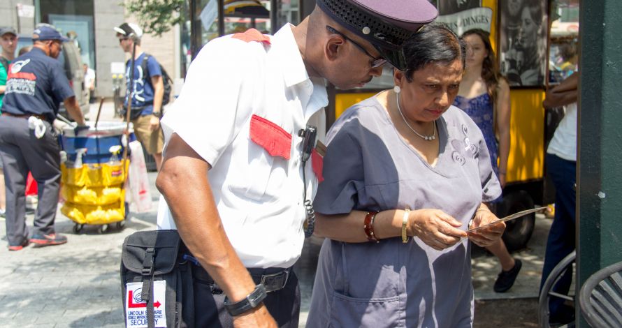 Public Safety Officer answers a question for a pedestrian with a brochure