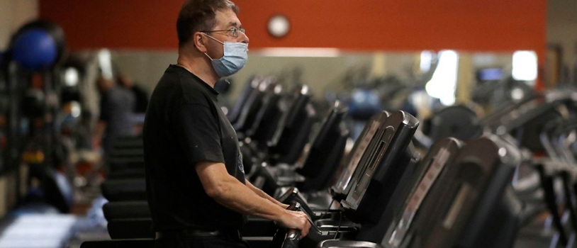 man wearing a mask on a treadmill in a gym
